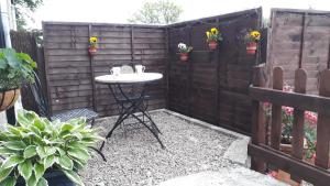 a small backyard with a table and a fence at Paula's Cottage in New Pitsligo