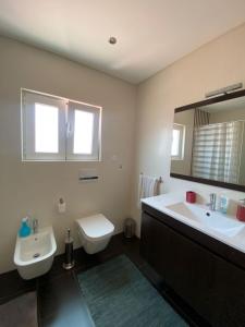 a bathroom with a sink and a tub and a toilet at Arthouse Surf Ericeira in Ericeira