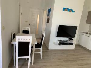 een kleine keuken met een tafel en een tv in een kamer bij Apartman Demi in Miškovići