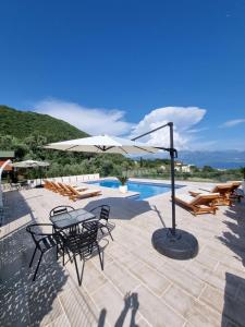een terras met een tafel, stoelen en een parasol bij Apartments Blazevic in Herceg-Novi