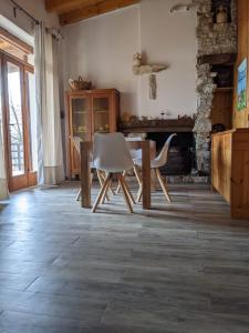 uma sala de estar com uma mesa e cadeiras e uma lareira em La casetta nel bosco em Salò