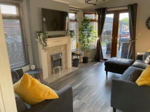 a living room with two couches and a fireplace at Lakeside 18 in Warton