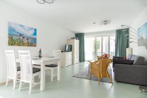 een keuken en een woonkamer met een tafel en stoelen bij Neubau-Villa-Strandidyll-Typ-4-Apartment-1-2 in Binz