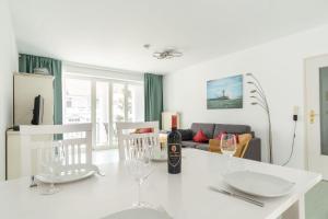 een witte tafel met glazen en een fles wijn bij Neubau-Villa-Strandidyll-Typ-4-Apartment-1-2 in Binz