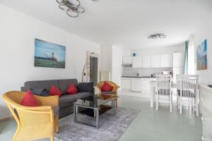 een woonkamer met een bank en een keuken bij Neubau-Villa-Strandidyll-Typ-4-Apartment-1-2 in Binz