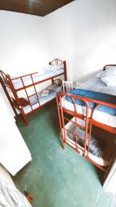 聖若澤杜斯坎普斯的住宿－Hostel Dona Lucia，一间客房设有两张双层床,其中配有水