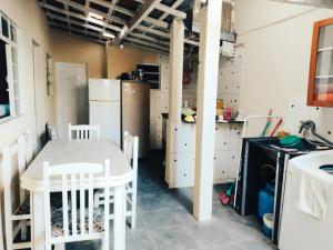 a kitchen with a table and chairs and a refrigerator at Hostel Dona Lucia in São José dos Campos