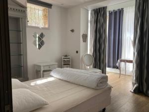une chambre avec deux lits et une chaise et une fenêtre dans l'établissement Gîte Comme à la maison, à Hyères