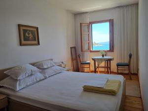 um quarto com uma cama, uma janela e uma mesa em Apartment Ružica em Tribunj