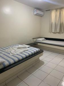 a room with two beds and a window in it at Hotel Piramide St. Antonio de Jesus in Santo Antônio de Jesus