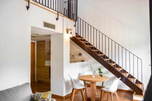 un soggiorno con un tavolo e una scala di Loft Besalú - alojamiento céntrico y acogedor a Besalú