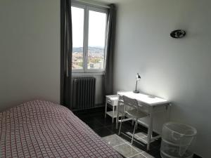 een slaapkamer met een bed, een bureau en een raam bij Tout confort Toulon centre appartement 3 chambres, vue sur la Rade in Toulon