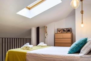 una camera da letto con letto con lenzuola gialle e cuscini blu di Loft Besalú - alojamiento céntrico y acogedor a Besalú