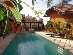 ein Haus mit einem Swimmingpool vor einem Haus in der Unterkunft Suite Lanka in Hikkaduwa
