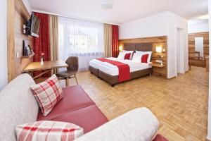 ミュンヘンにあるPark Hotel Laim Serviced Apartmentsのベッドとソファ付きのホテルルーム
