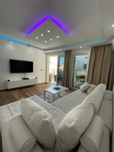 a living room with a large bed and a tv at Coco apartments in Petrovac na Moru