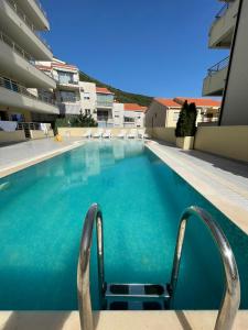 a swimming pool with a chair in the middle at Coco apartments in Petrovac na Moru