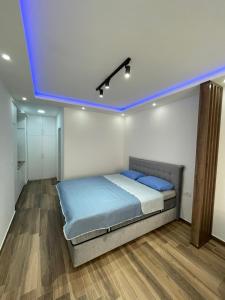 a bedroom with a bed with a blue ceiling at Coco apartments in Petrovac na Moru +17 photos