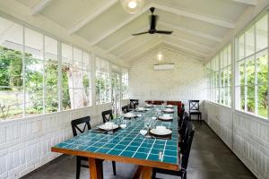 une salle à manger avec une table bleue et des chaises dans l'établissement StayVista's Villaggio - Orchard Oasis with Pool, Expansive Lawn, Patio & Indoor Activities, à Nashik