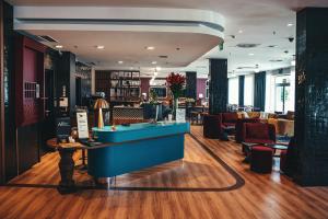 un salon avec un comptoir bleu au milieu d'une pièce dans l'établissement ibis Styles Wałbrzych, à Wałbrzych