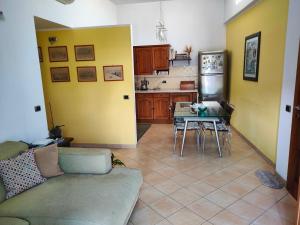Visitponza - Vesta في بونسا: غرفة معيشة مع أريكة وطاولة ومطبخ
