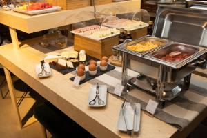 a breakfast buffet with eggs and food on a counter at Charm Palace Porto in Porto