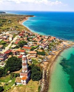 Luftaufnahme eines Strandes mit Häusern und dem Meer in der Unterkunft Вила за гости Даная-Фар Шабла in Tyulenovo