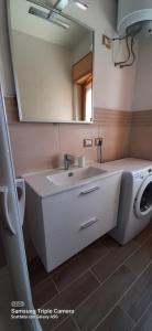 een badkamer met een wastafel en een wasmachine bij Trilocale a Scalea in Scalea