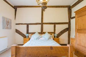 Säng eller sängar i ett rum på Plum Pudding Cottage by Bloom Stays