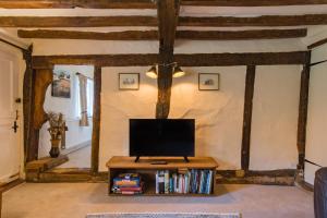 En tv och/eller ett underhållningssystem på Plum Pudding Cottage by Bloom Stays