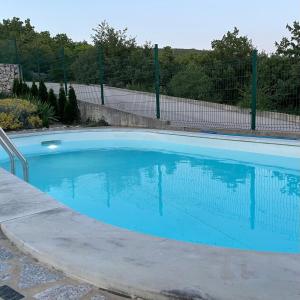 a large blue swimming pool with a fence at Anai Jadranovo in Jadranovo