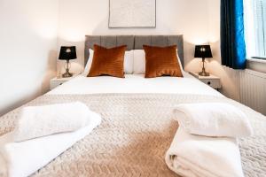 sypialnia z dużym łóżkiem z białą pościelą i poduszkami w obiekcie Beech Road Apartment St Albans by PAY AS U STAY w Saint Albans