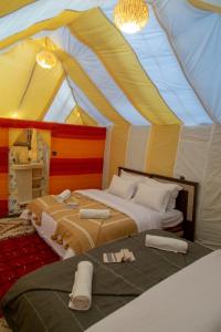 a bedroom with two beds in a tent at Merzouga Premium Desert Camps in Merzouga