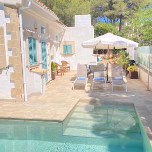a pool with a table and chairs and an umbrella at VILLA HERDAIN in Cielo de Bonaire 