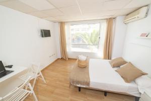 1 dormitorio con cama, escritorio y ventana en Old Town La Estación, en Alicante