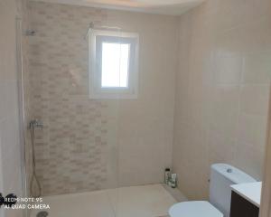 a bathroom with a toilet and a window at Galdana Sun And Beach in Cala Galdana