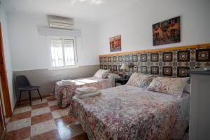 - une chambre avec deux lits, une table et une chaise dans l'établissement Apartamentos El Palmeral, à Conil de la Frontera