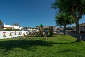 a playground with a slide in a park at Apartamentos El Palmeral in Conil de la Frontera