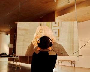 a woman wearing headphones in front of a large screen at East Quay in Watchet