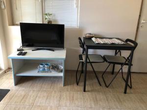 a desk with a television and a table with a chair at Ssenyange Guest House in Varna City