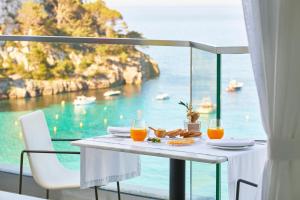 a table with food and orange juice on a balcony at Meliá Cala Galdana in Cala Galdana