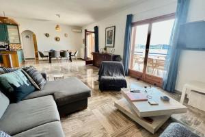 een woonkamer met een bank en een tafel bij Chrysa's Dream - Dreamy Sea View at Spacious 3BR Apt in Porto Cheli in Porto Cheli