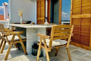 a kitchen with a table and chairs on a patio at Chrysa's Dream - Dreamy Sea View at Spacious 3BR Apt in Porto Cheli in Porto Heli