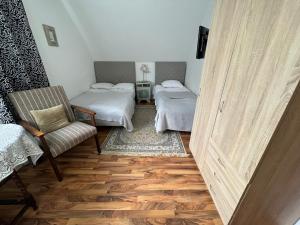 a room with two beds and a chair and a door at Topoliu 16 guesthouse in Šventoji