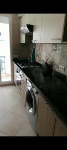 a kitchen with a sink and a stove top oven at Résidence Haute Standing Corniche in Martil +8 photos