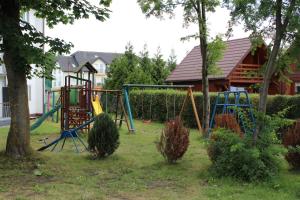 a playground in a yard with trees and a house at OWR Piramida 2 in Darlowko