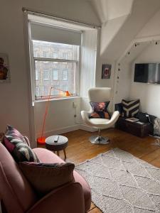 a living room with a couch and a chair and a window at Royal Mile View in Edinburgh