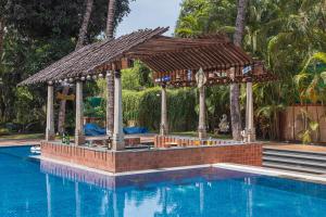 Saffronstays Casa Del Palms, Alibaug - luxury pool villa with chic interiors, alfresco dining and island bar في آليباغ: مسبح مع شرفة بجانب مسبح