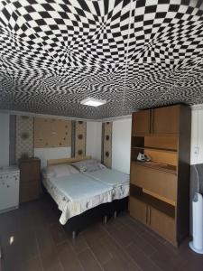 a bedroom with a bed and a black and white patterned ceiling at Edit Vendégház in Tiszaújváros +48 photos