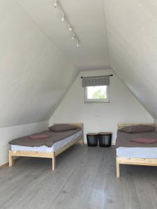 two beds in a room in a attic at Laukbaloži Holiday houses in Jūrkalne